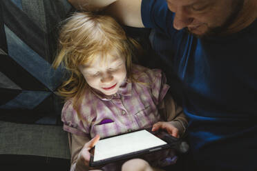 Tochter lernt mit Tablet-PC und sitzt bei ihrem Vater - IHF01426