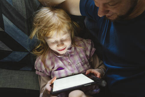 Tochter lernt mit Tablet-PC und sitzt bei ihrem Vater - IHF01426