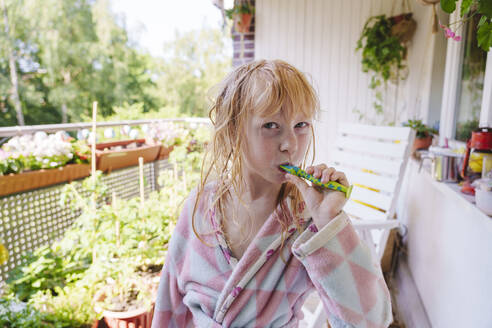 Blond girl brushing teeth standing in balcony - IHF01437