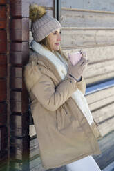 Nachdenkliche Frau genießt Kaffee im Winter - JSMF02777