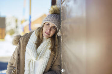 Thoughtful woman leaning on wall in winter - JSMF02778