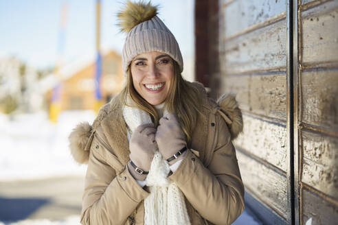 Smiling woman feeling cold in winter - JSMF02780