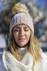 Gelassene Frau mit geschlossenen Augen im Winter - JSMF02798