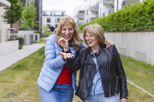 Happy mother giving key to daughter - IHF01453