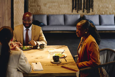 Business colleagues discussing on dining table at convention center - DSHF00852