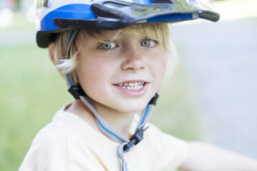 Glücklicher blonder Junge mit Fahrradhelm - NJAF00439