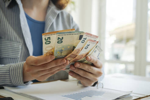 Young woman counting currency at home - OSF01809