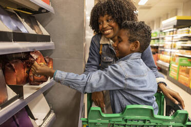 Glückliche Mutter und Sohn beim gemeinsamen Einkauf im Supermarkt - JCCMF10502
