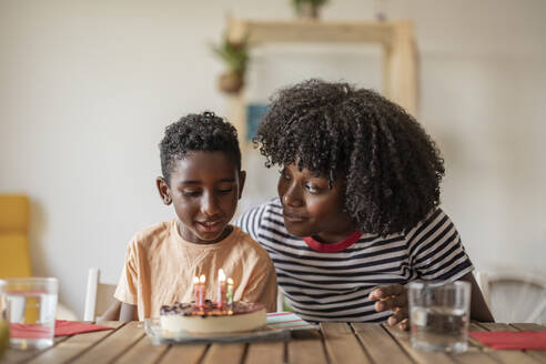 Lächelnde Mutter und Sohn feiern Geburtstag mit Kuchen - JCCMF10592