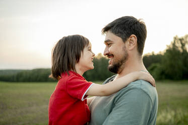 Glücklicher Vater mit Sohn auf dem Feld - ANAF01603