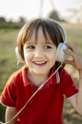 Happy boy listening to music with headphones - ANAF01619