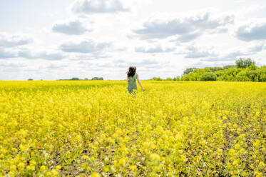 Woman running in field on sunny day - ANAF01635