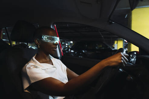 Geschäftsfrau, die eine intelligente Brille trägt und Auto fährt - PNAF05500