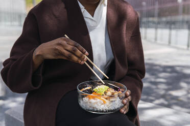 Businesswoman with chopsticks having lunch - PNAF05530