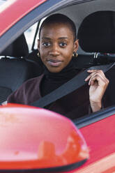 Young businesswoman adjusting car seat belt - PNAF05573