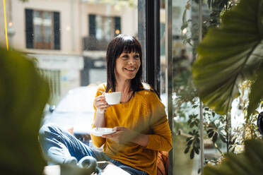 Smiling woman with coffee cup in cafe - JOSEF19733