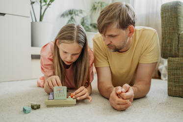 Vater und Tochter spielen zu Hause ein Spiel - ANAF01660