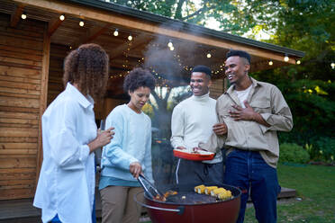 Lesbian and gay male couples enjoying barbecue in summer backyard - CAIF33483