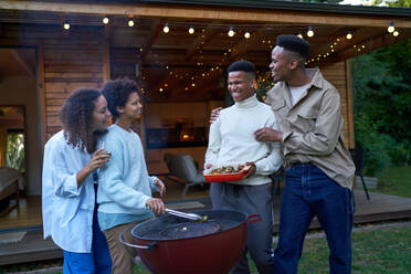 Gay couples bonding, enjoying barbecue in summer backyard - CAIF33485