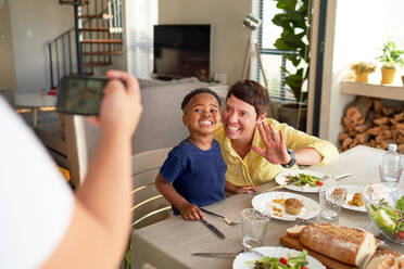 Happy mother and son posing for photo at dinner table - CAIF33646