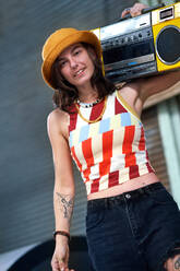 Portrait confident young woman holding boom box - CAIF33656