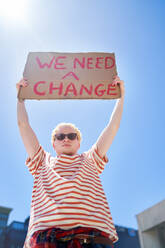 Portrait confident young male protester holding change sign - CAIF33703