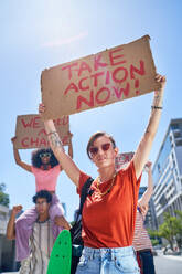 Portrait young protesters holding change signs in sunny city - CAIF33708