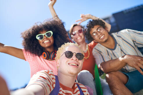 Junge Freunde fangen einen fröhlichen Moment in der Stadt mit einem sonnigen Selfie-POV-Porträt ein. - CAIF33716