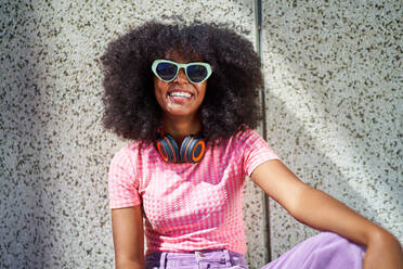 Portrait happy young woman in sunglasses with headphones - CAIF33733