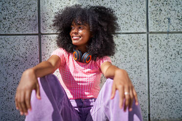 Portrait happy, cool young woman with headphones at wall - CAIF33734