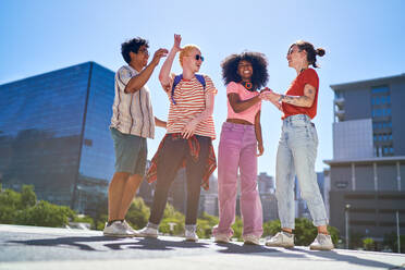 Happy young friends laughing in sunny city park - CAIF33739