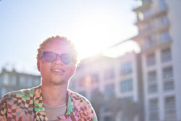 Portrait happy young man in sunny city - CAIF33769