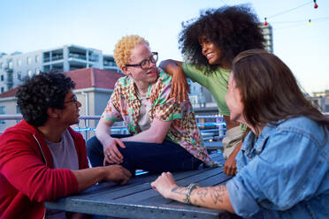 Young friends talking, hanging out on urban balcony - CAIF33784