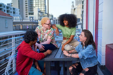 Happy young friends hanging out on urban balcony - CAIF33785