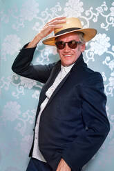 Portrait carefree, stylish senior man in hat and sunglasses - CAIF33846