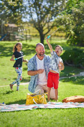 Happy father and son with Down Syndrome playing with bubble wand - CAIF33951