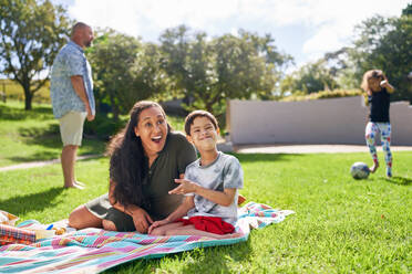 Portrait happy mother and son with Down Syndrome in sunny park - CAIF33958