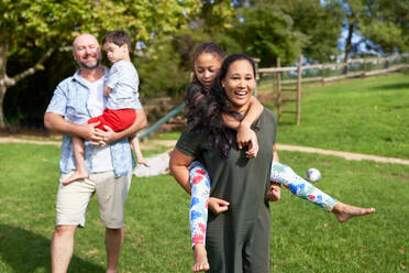 Portrait happy, carefree family in sunny summer park - CAIF33961