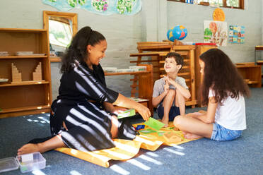 Happy family playing on floor at home - CAIF33993