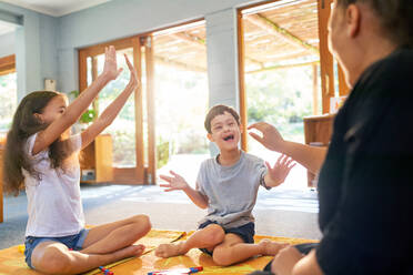 Happy boy with Down Syndrome playing on floor with family - CAIF33997