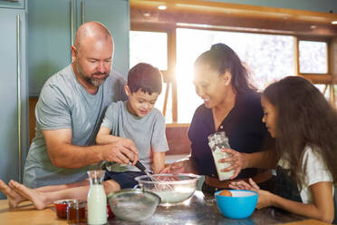 Happy family baking together in kitchen at home - CAIF34005