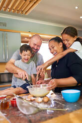 Happy family baking together in kitchen at home - CAIF34014