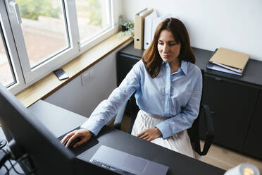 Geschäftsfrau mit Computer am Schreibtisch im Büro - EBSF03647