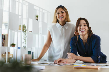 Glückliche Geschäftsfrauen am Schreibtisch im Kreativbüro - EBSF03659