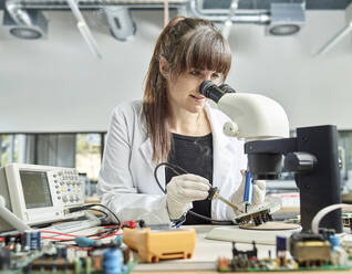 Wissenschaftlerin beim Löten einer Leiterplatte im Labor - CVF02470