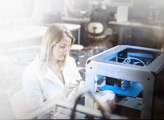 Engineer examining 3d printer in laboratory - CVF02477