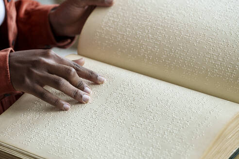 Hands of woman reading braille text - AAZF00770