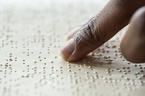 Woman reading braille text from book - AAZF00771