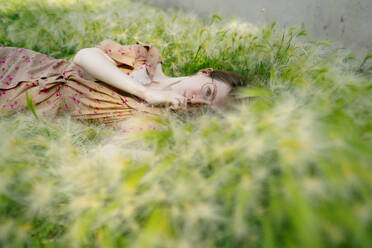 Portrait of woman lying on grass - TETF01990