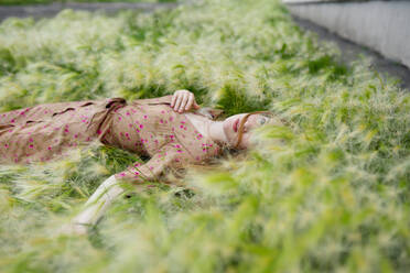 Portrait of woman lying on grass - TETF01991